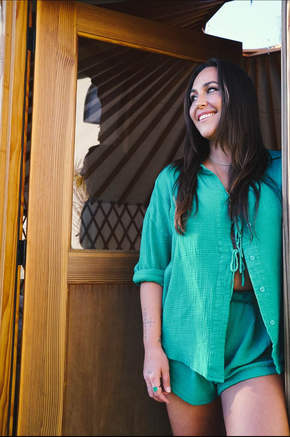 Sasha smiling in the doorway of her yurt
